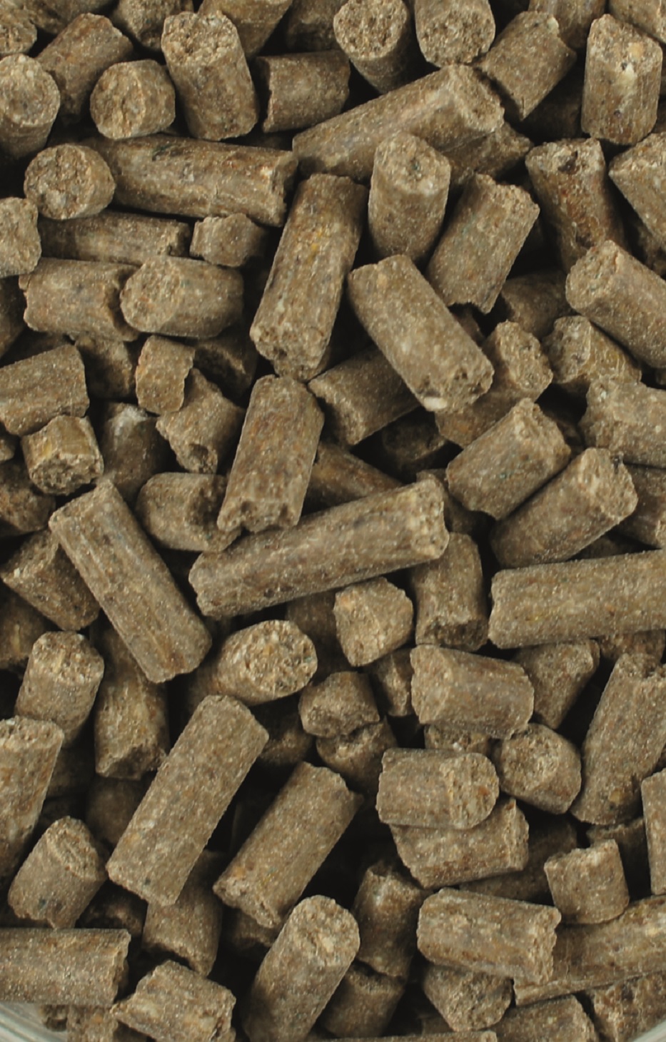 Braune Pellets aus komprimiertem Material, unregelmäßig geformt und dicht gepackt.