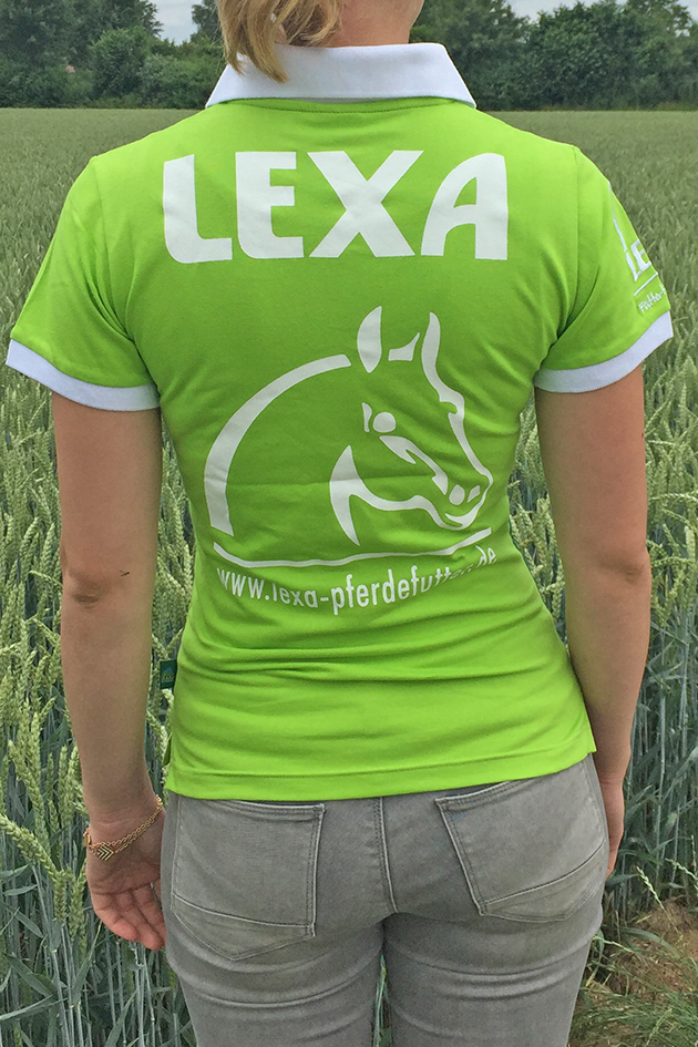 Rückansicht einer Person in einem grünen Poloshirt mit dem Aufdruck 'LEXA' und einem Pferdekopf-Logo, vor einem Weizenfeld.