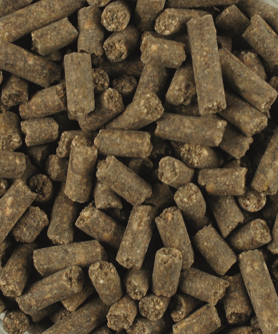 Braune, zylindrische Pellets, dicht gepackt, möglicherweise Tierfutter oder Düngemittel.