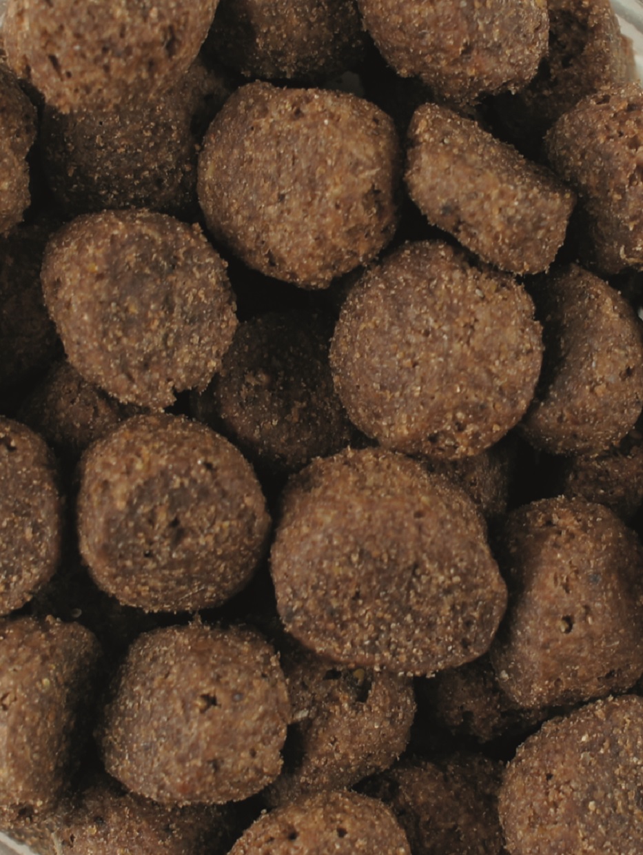 Braune, runde Tierfutter-Kroketten in einer Schüssel.