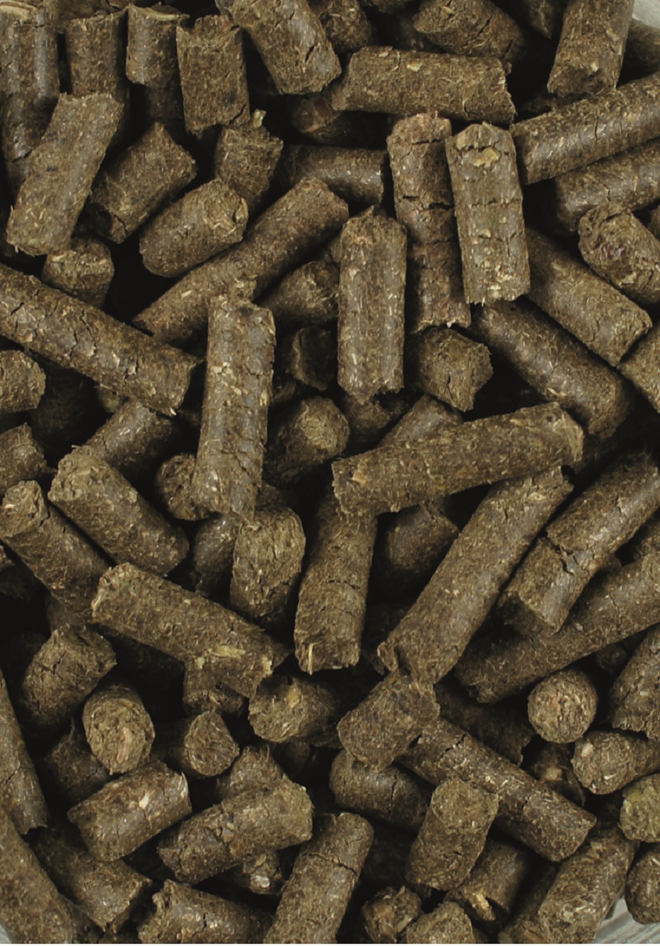Braune Tierfutterpellets in verschiedenen Formen und Größen, dicht gepackt.