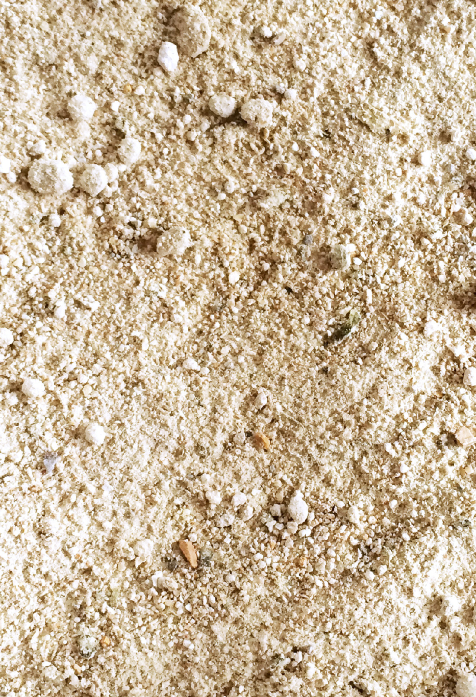 Feines, helles Mehl mit kleinen Körnern und unregelmäßigen Texturen.